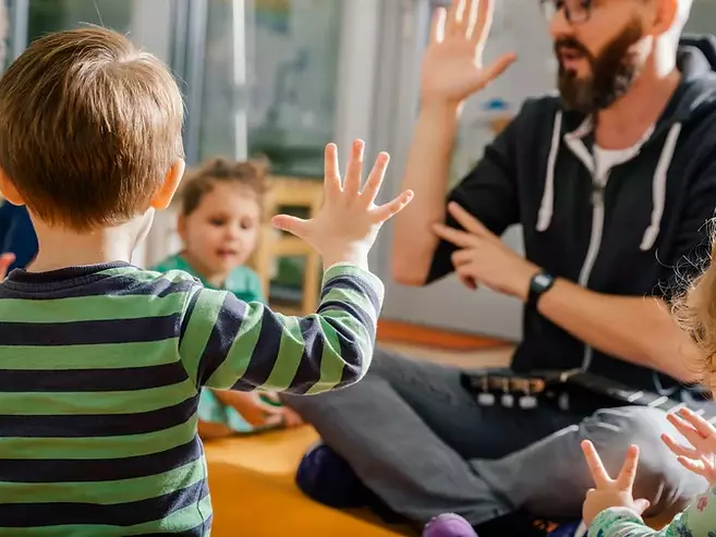 Male teacher teaching toddlers numbers