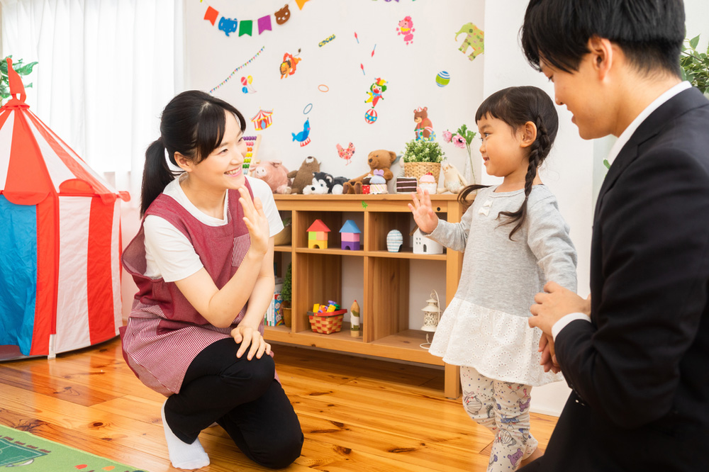 Teacher waving to parent and young student