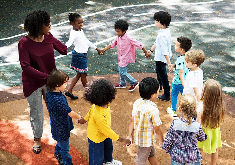 Teacher with students holding hands in a circle