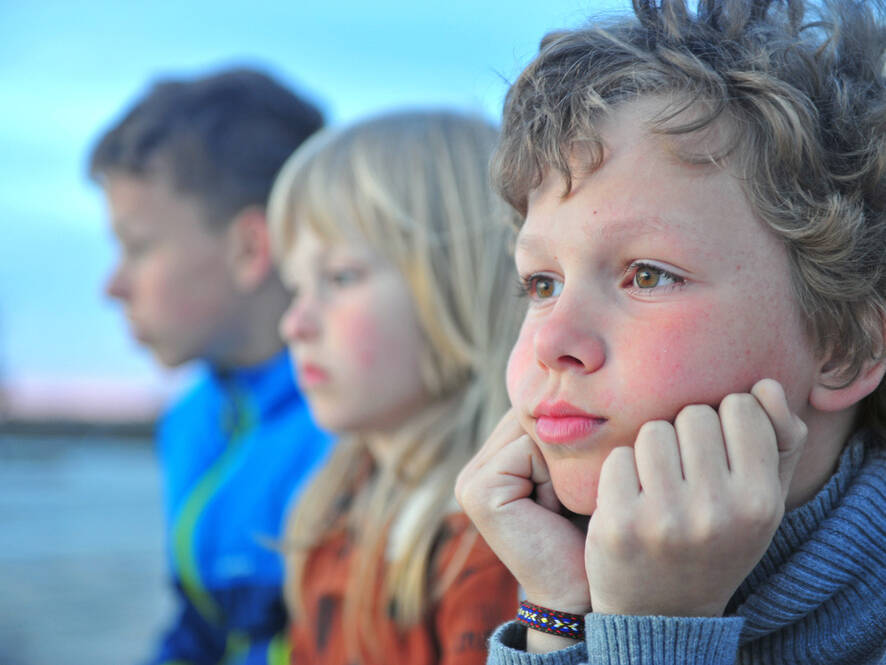 little boy with group of friends looking sad