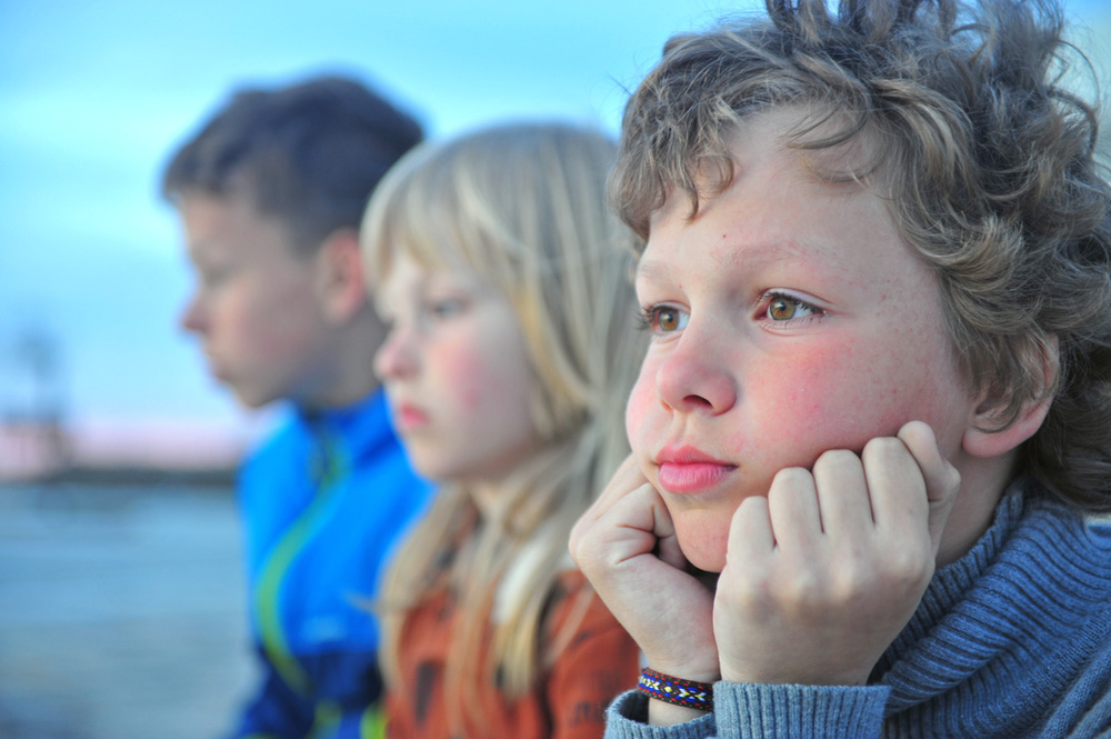 little boy with group of friends looking sad