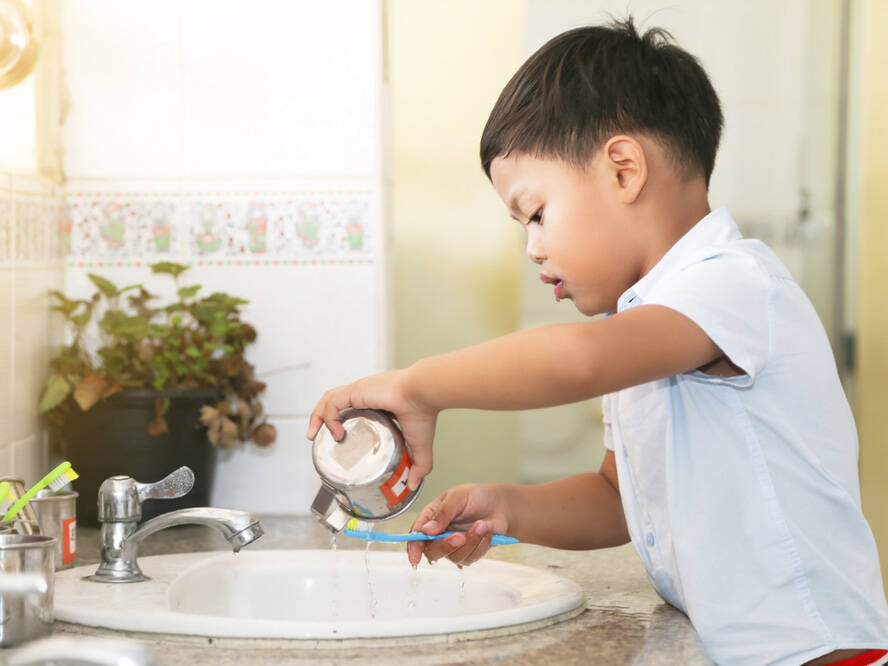 young boy in the bathroom brushing his teeth