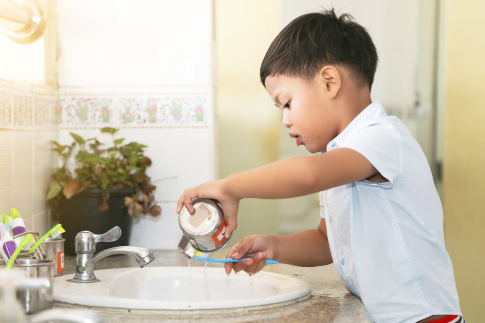 young boy in the bathroom brushing his teeth