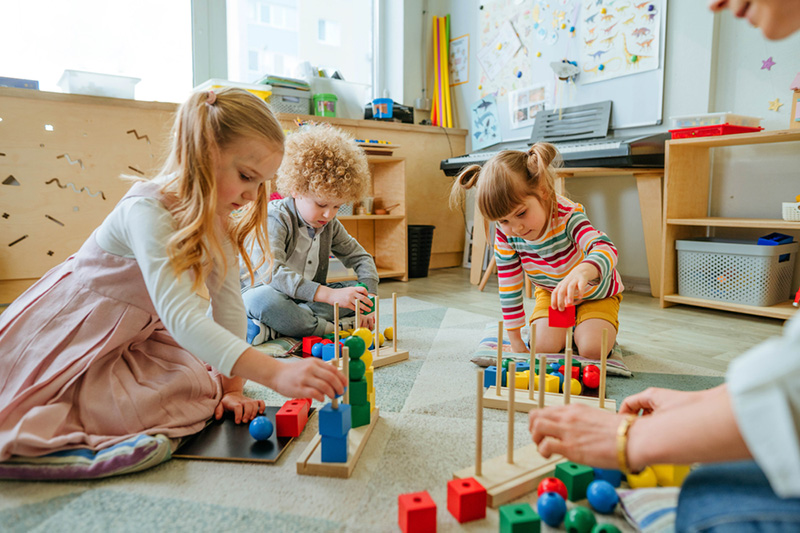 2 little girls playing with blocks in the classroom