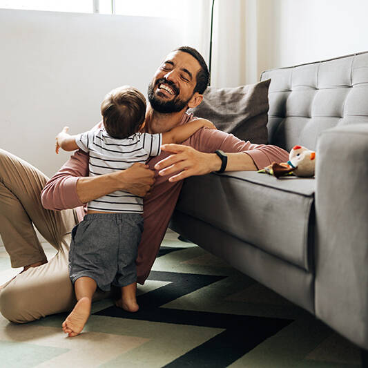 Happy father hugging little son at home