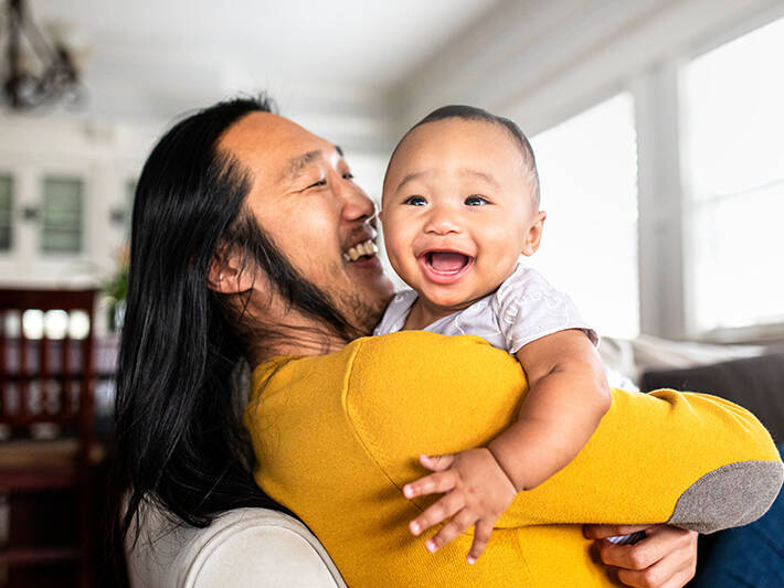 Father holding baby boy and smiling