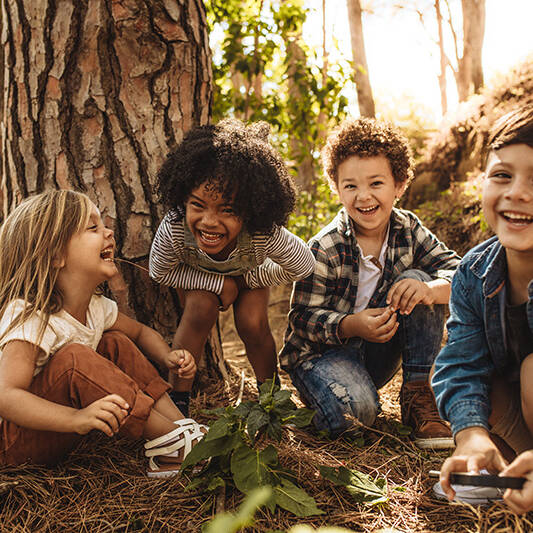 Four Kids sin the forest together laughing and having fun