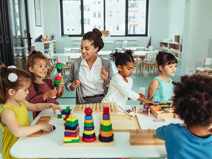 Teacher playing with kids at a table