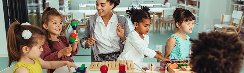 Teacher playing with kids at a table