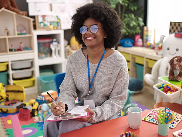 Teacher smiling at camera while sitting in classroom