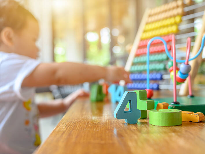 Toddler plays with number blocks