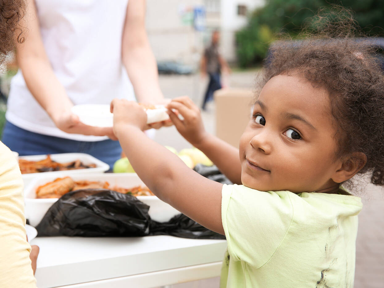 girl grabbing a plate of food