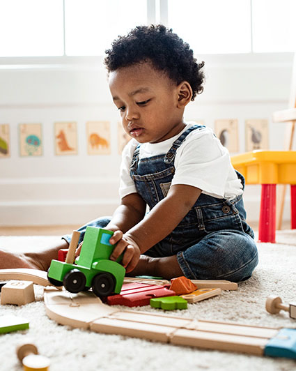 Cute little boy playing with a railroad train