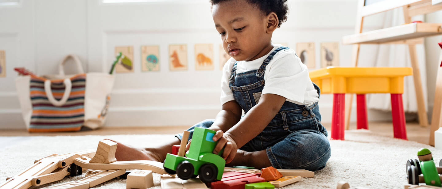 Cute little boy playing with a railroad train toy